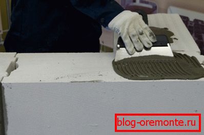 Stavljajući ljepilo na betonski blok Stavljajući ljepilo na betonski blok