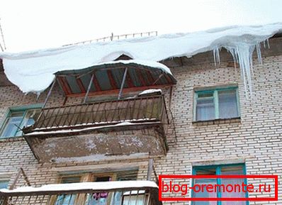Icicles i snijeg na krovu